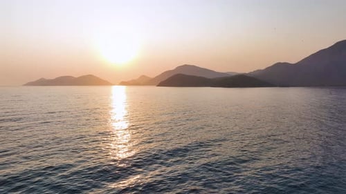 Warm Sunlight Reflects on the Tranquil Ocean Surface Creating a Shimmering Path Towards the Rising