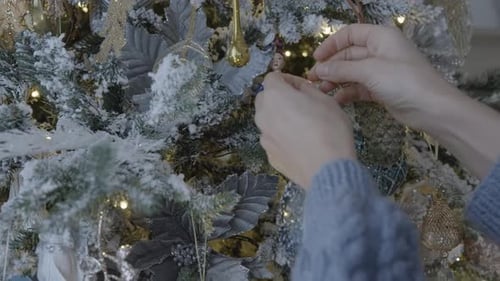 Hands Decorating Beautiful Christmas Tree with Ornaments