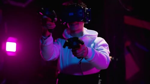 Boy playing VR games in a studio with blue pink neon lights
