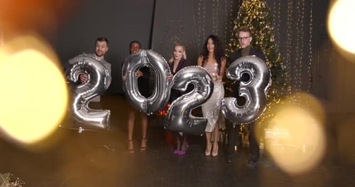 Friends Celebrating New Year's Eve Holding 2023 Balloons