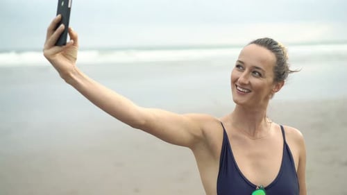 Attractive woman takes a selfie photo on a sunny beach vacation day