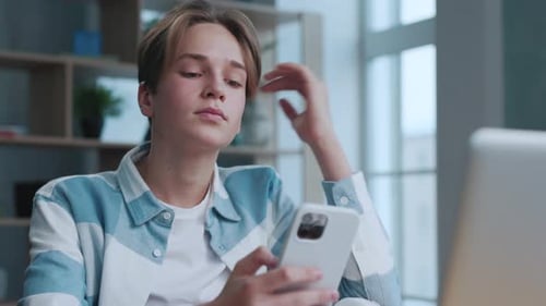 Handsome Teen Using Smartphone in Home Room at Side View. Attractive Young