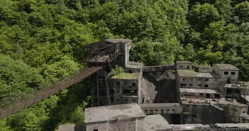 Rusty freight cableway platform and ruined factory buildings, Georgia.