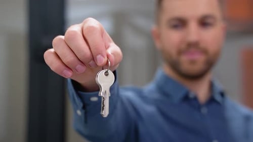 Close Up of Friendly Manager in Window Shop with Keys
