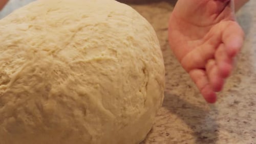 Ball of Dough in Hands on Counter