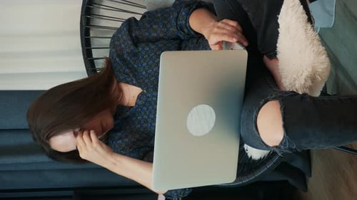 Woman Working on Laptop in Chair at Home