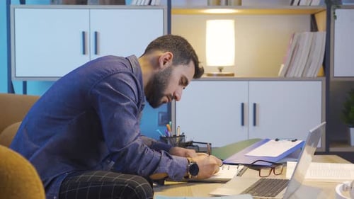 Young Adult Working on Laptop at Home Office