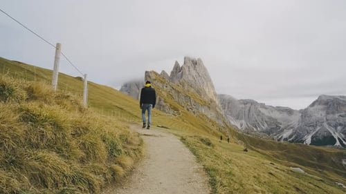 Man Traveler Walks to the Famous Mount Seceda in the Dolomites Mountain Trail in Alps Mountains in