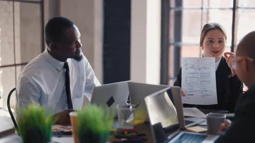 Une patronne sérieuse discute avec des employés du bureau de la conférence de l'entreprise, chef de département