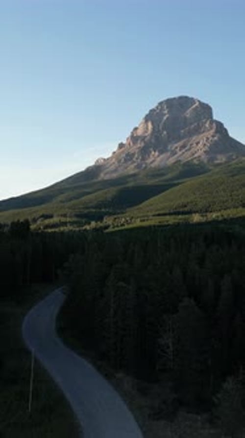 Winding Road Through Forest Toward Mountain Peak. Crowsnest Pass, AB, Canada.