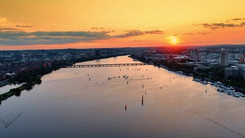Flying above the Charles River in Boston. Splendid cityscape and waterscape in orange rays