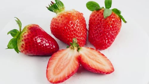Rotating ripe juicy strawberries on a white background.