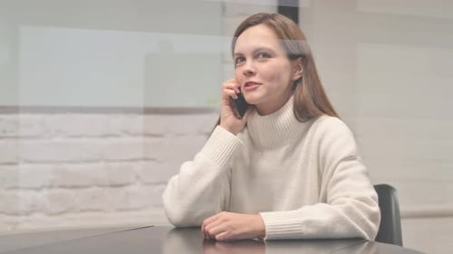 Woman Speaking on Smartphone in Bright Modern Office
