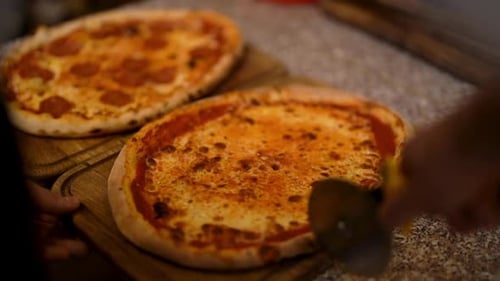 Crop Chef Slicing Margherita Pizza in Kitchen