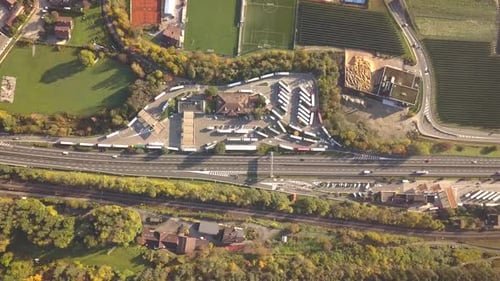 Top Down Aerial View of Highway Interstate Road with Fast Moving Traffic and Parking Lot with Parked