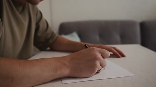 Adult Drawing on Paper with Pen Indoors