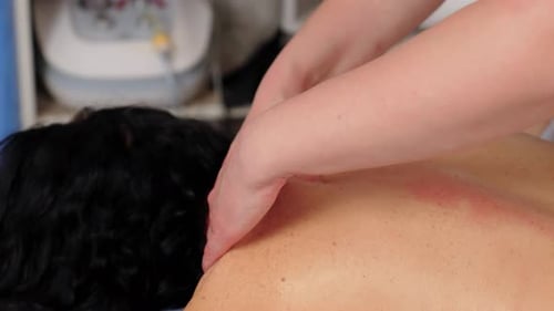 Entspannte Frau liegt während der manuellen Revitalisierung auf der Couch im Schönheitssalon oder in der medizinischen Klinik