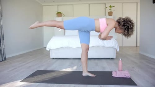 Woman Practicing Balancing Yoga Pose at Home