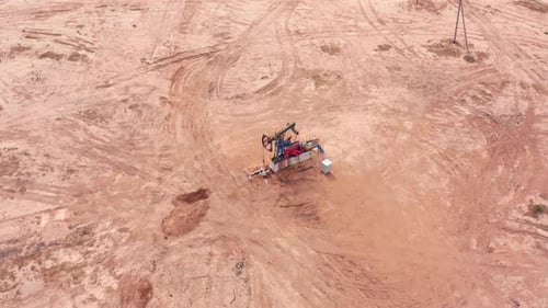 Bomba de aceite industrial Jack perforando petróleo crudo en un campo desértico