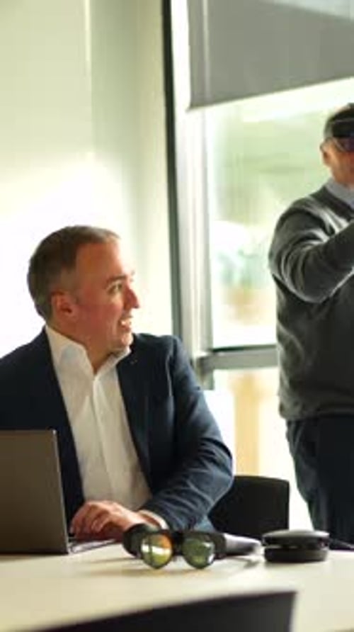 Businessman Showing Innovative Augmented Mixed Reality Goggles to a Client