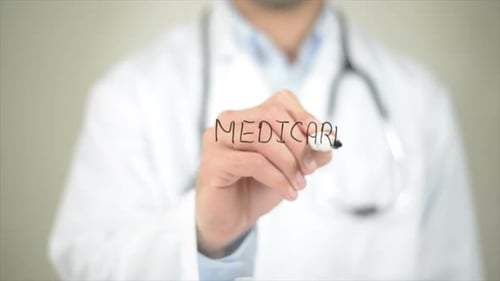 Doctor Writes the Word Medicare on Clear Screen