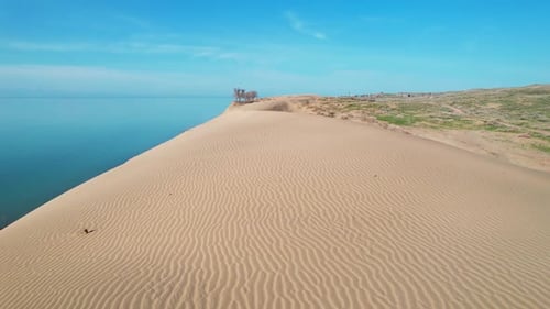 Desert Dune with Blue Sea at Sunrise