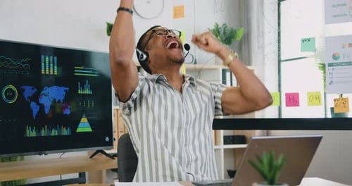 Excited Young Man Celebrates Success at Office Desk