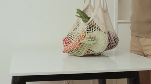 Man Places Vegetables on Kitchen Table