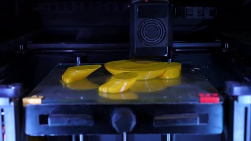 Une imprimante 3D imprime des figures blanches sur fond gris en gros plan