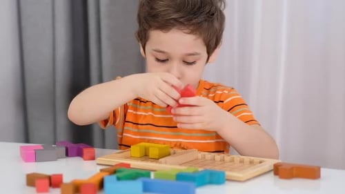 Close Up of Child's Hands Playing with Colorful Wooden Bricks at the Table Stock Footage Slow Motion
