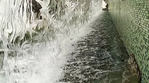 A
água cai de perto ou da fonte para uma pequena piscina na cidade. Câmera lenta