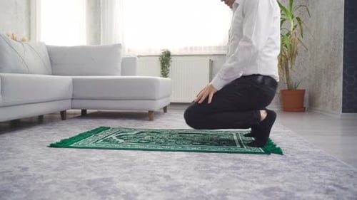 Adult Male Bowing on Rug in Living Room