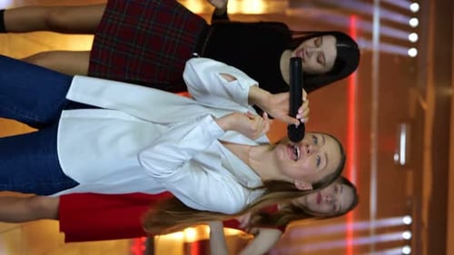 Energetic Young Women Singing and Dancing on Stage