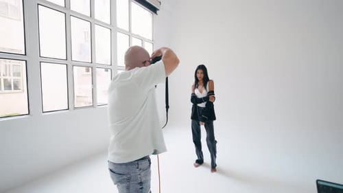 Photographer Taking Pictures of Model in White Studio