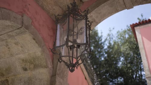 Ornate Lantern Hanging from Stone European Archway