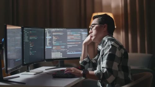 Asiatischer männlicher Programmierer langweilt sich beim Erstellen eines Softwareingenieurs, der App und Programm entwickelt