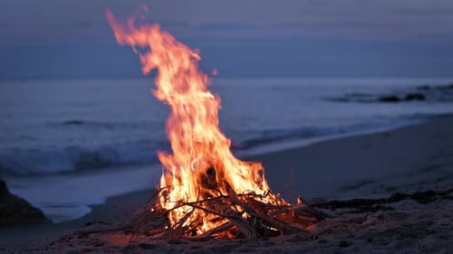 Abends brennt ein Lagerfeuer an einem verlassenen Sandstrand an der Küste