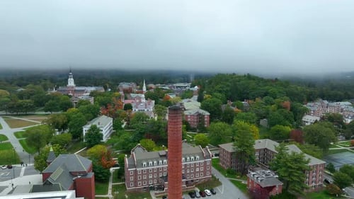Orbiting aerial shot of college campus in the northeast. Academic lawn and dorms featured under over