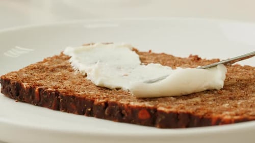 Cream Cheese Being Spread on a Slice of Bread