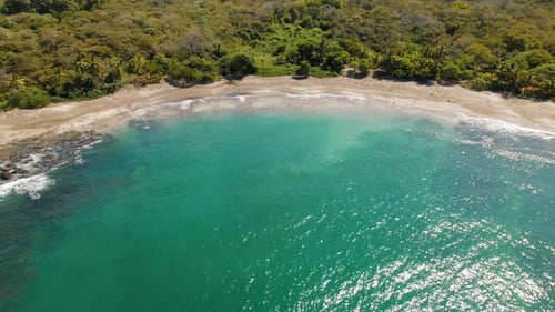 Tropical bay with turquoise ocean water and forest at Pitahaya beach Costa Rica
