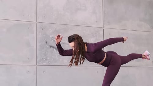 Close-up. Beautiful sportive woman trainer makes a bend, jump, lunge. Fitness, health and beauty. Sl