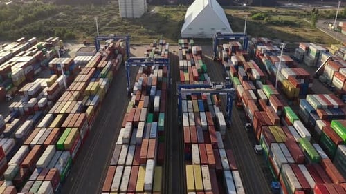 Riesiges Logistikzentrum mit Reihen von Schiffscontainern bei Sonnenuntergang