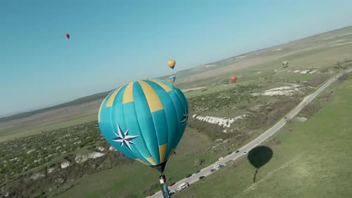 Hot Air Balloons Drifting Over Rural Landscape