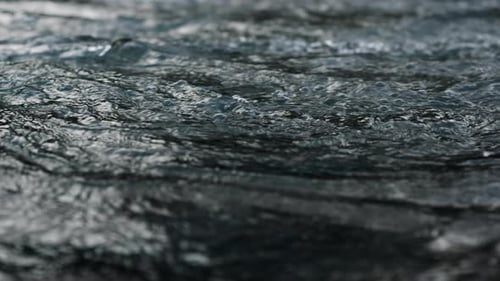 Mountain river wild stream flowing with splashing water in slow motion