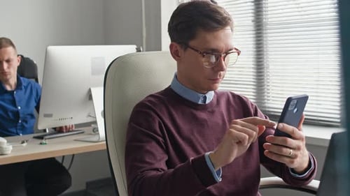 Male Manager Talking Business on Phone Call with Client while Working at Office