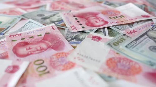 Hundred yuan RMB and hundred USD, Chinese and American paper money, flowing on the table, close up
