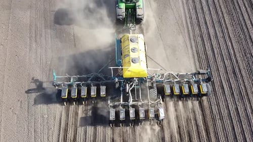 Tractor with yellow seeder working on the field in Ukraine OA Lexa