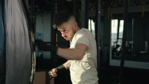 Man Training Boxing at Gym with Punching Bag