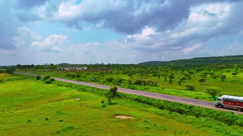 video of a Truck drives on the road between beautiful fields with pretty