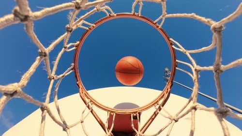 Basketball trifft perfekt auf den Korb und sorgt in Zeitlupe für einen sanften Netzschwung